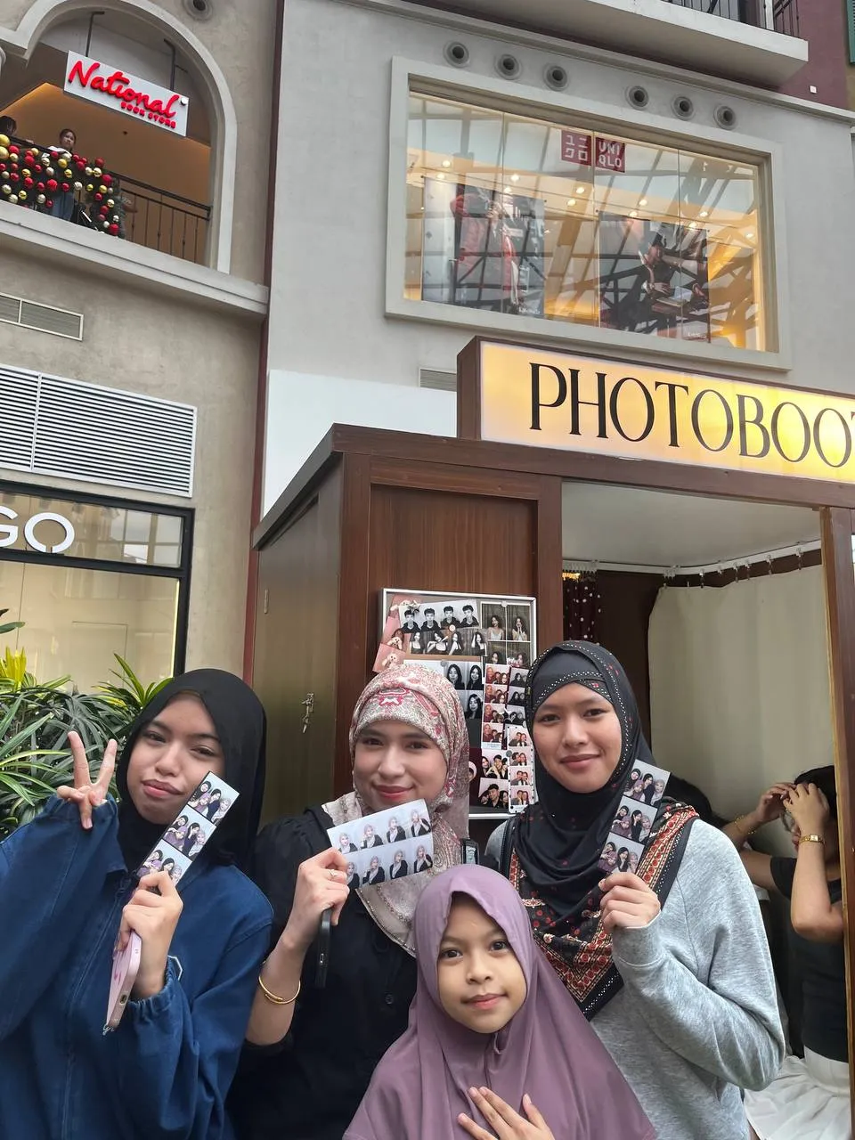 A group of guests with a child showing their photographs at Evia.