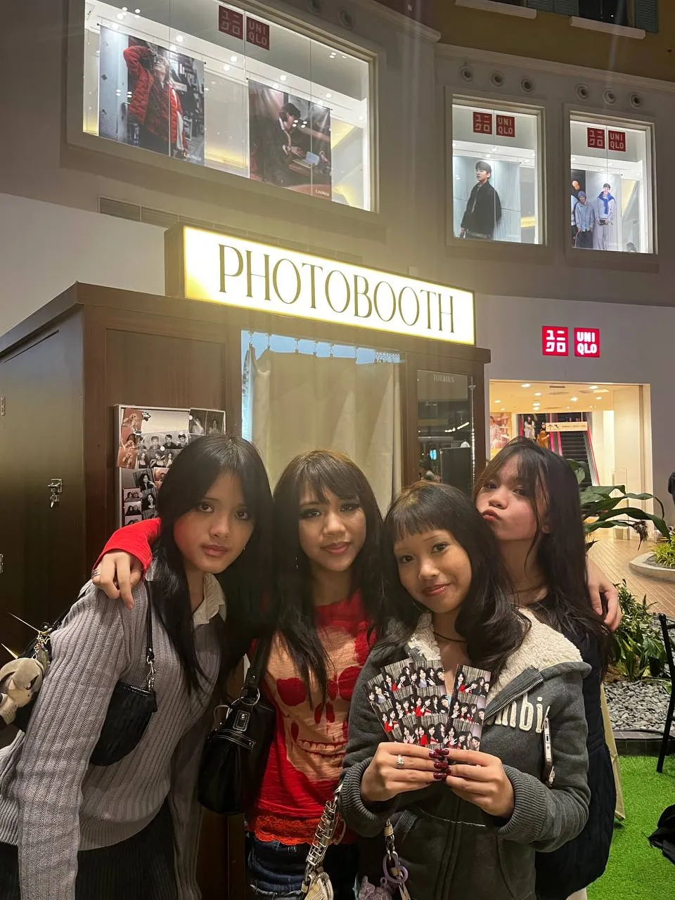 Four friends holding their Photo Strips outside FOTOHAVN at Evia.