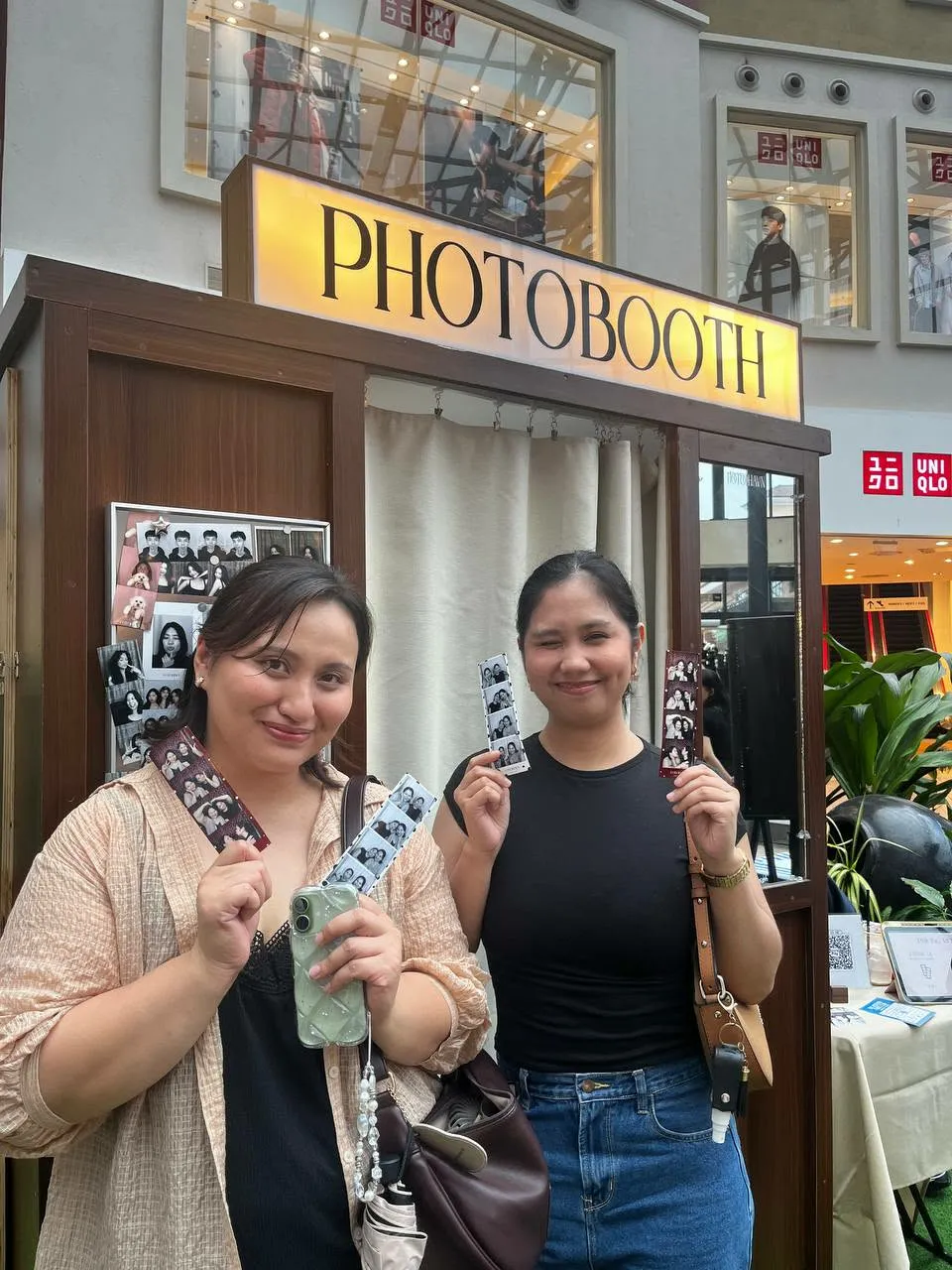 Two smiling guests holding up their Photo Strips.